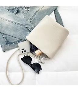 Interior view of white pebble leather bucket bag showing smartphone and perfume storage
