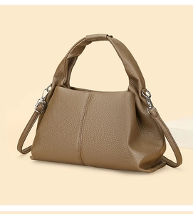 Detail of caramel brown cloud dumpling bag with knotted handle and lychee leather texture