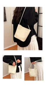 Detail view of cream bucket bag showing lychee grain texture and rope knot strap