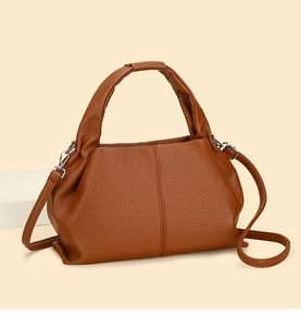 Close-up of brown litchi pattern leather texture and silver metal buckle on handbag