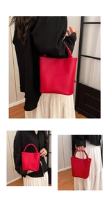 Detail of red bucket bag with lychee texture leather and braided handle design