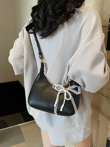 Sac demi-lune en cuir noir avec nœud en dentelle blanche et pendentif en perle