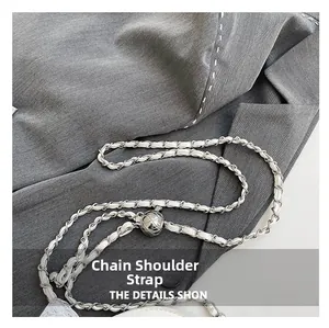 Detail of silver metal chain strap with white leather and spherical quilting adjustment ball