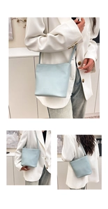 Detail of light blue bucket bag showing premium lychee grain leather and brand embossing