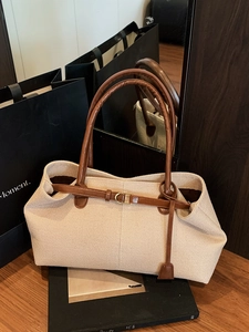 Chic beige woven tote bag with brown leather handles and gold D-ring accents for daily use