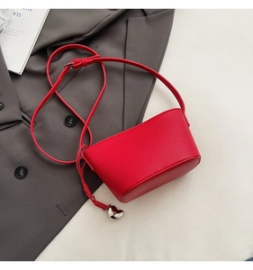 Detail view of red lychee grain leather bucket bag with silver heart zipper charm