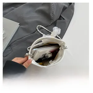 Quilted white bucket bag showing internal capacity with phone, lipstick and lace bow