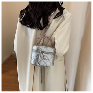 Mini borsa a scatola trapuntata argento con tracolla a catena indossata da modella