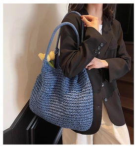 Close-up of blue woven tote bag showing texture and capacity with yellow tulip accent