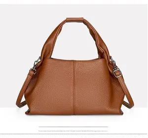 Detailed macro shot of brown lychee grain leather and adjustable strap metal buckle