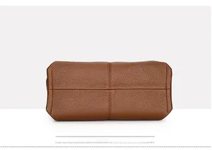 Detailed view of the brown lychee pattern leather bag bottom with reinforced stitching