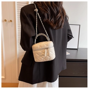 Detailed back view of a white quilted box bag with dual zippers and chain strap worn by model