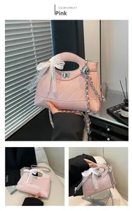 Detail of pink quilted bucket bag with lace bow, chain strap and silver twist lock