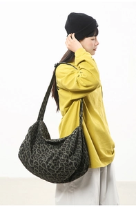 Detail of dark green leopard print canvas hobo bag with wide shoulder strap