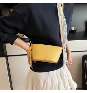 Close-up of bright yellow lychee texture leather bag with Clearyn logo and knot detail