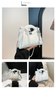 Close-up of white quilted bucket bag with lace bow detail and silver twist lock