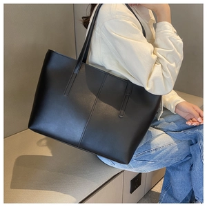 Close-up of black matte PU leather tote bag showing large capacity and vertical stitching
