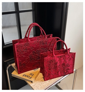 Macro detail of red jacquard texture on two-piece bridal tote bag set for weddings