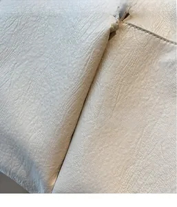 Close-up of lightweight off-white pebble grain leather texture with natural soft folds