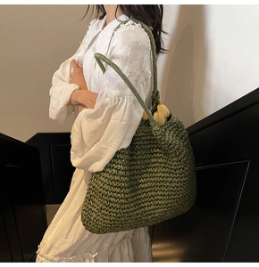 Detailed texture of green woven tote bag carried by woman in floral dress