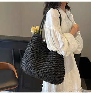 Lifestyle shot of black woven tote bag with yellow tulips and white lace dress