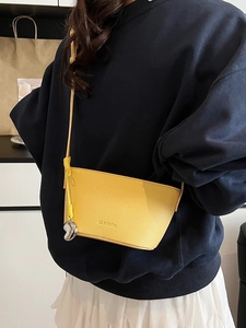 Large yellow lychee leather shoulder bag with Clearon logo and silver pendant charm