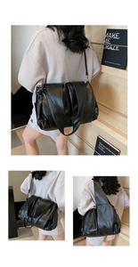 Detail view of large black slouchy tote bag featuring glossy soft leather and pleats