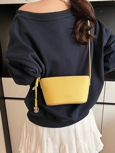 Large yellow lychee texture shoulder bag with heart pendant shown on model
