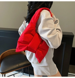 Détail d'un grand sac fourre-tout rouge en forme de nœud avec un tissu rembourré
