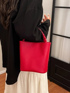 Minimalist red leather bucket bag with twist handle and Studio Bag embossed logo