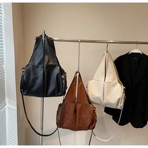 Detailed view of large capacity tote bags in black, brown, and beige textured leather