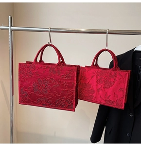 Detail of red floral embossed embroidery on two sizes of elegant bridal tote bags