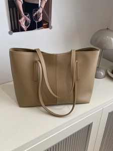 Minimalist khaki large capacity tote bag in PU leather on a modern side cabinet