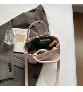 Détail de l'intérieur du sac seau rose montrant l'espace pour téléphone et maquillage