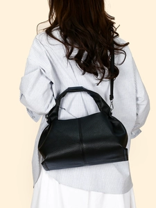 Black lychee leather cloud dumpling bag with wide handle and adjustable shoulder strap