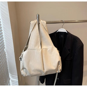 Close-up of beige large tote bag with soft pleated leather texture and drawstring detail