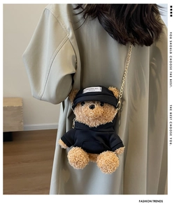 Detail of cute teddy bear plush crossbody bag with black hoodie and metal chain strap