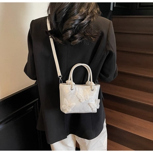 Détail de la broderie papillon exquise sur un sac seau blanc de style chinois