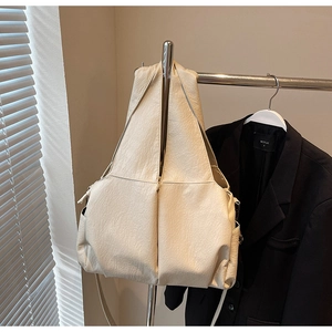 Detail of soft cream-colored PU leather texture on a large minimalist hobo bag