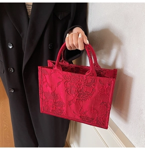 Detail of red floral jacquard bridal tote bag with intricate textured embroidery