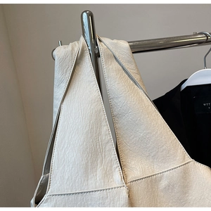 Detailed texture of off-white lychee pattern leather on a large minimalist hobo bag