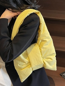 Grand sac cabas jaune matelassé avec nœud porté par un mannequin en extérieur