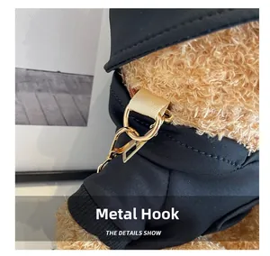 Detail of durable golden metal hook and D-ring on black fabric of plush bear bag