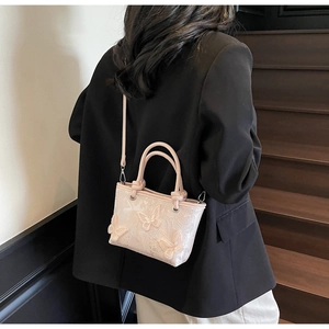Détail du sac seau en dentelle rose avec papillons 3D et bandoulière amovible