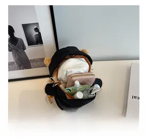 Detail showing internal capacity of the black plush bear bag with wallet and cosmetics