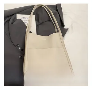 Detail of cream pebble grain tote bag featuring HOGOMU logo and exterior pocket