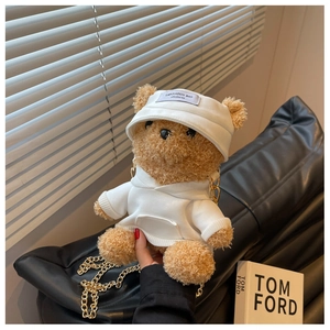 Detail of bear plush crossbody bag featuring golden chain strap and white hoodie accessory