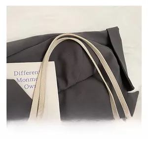 Detail of the soft lychee grain faux leather handle and neat stitching on a beige shoulder bag