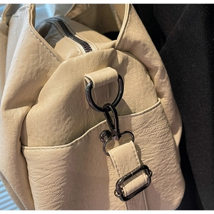 Close-up of litchi pattern leather shoulder bag with gunmetal hardware and zipper