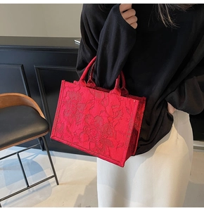 Detailed macro view of the red bridal tote bag featuring intricate 3D floral textures
